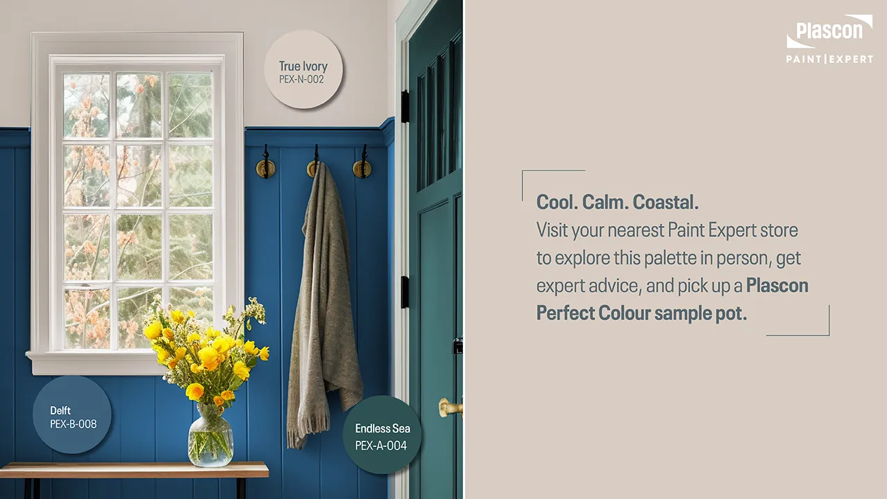 Coastal-inspired mudroom with Delft blue paneling, Endless Sea door, and True Ivory trim, styled with brass hooks and yellow flowers.